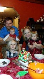 Megan Baril decorating a gingerbread house with her family